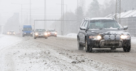 group of cars driving in a heavy snow area
